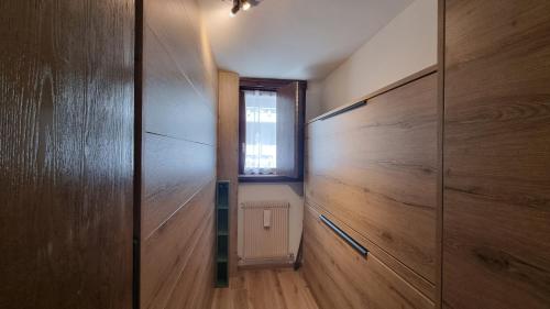 a hallway with wooden walls and a window at Ruscello Alpino in Mazzin