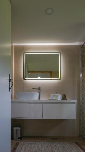 a bathroom with a sink and a mirror at A CASINHA DO CARREIRAS in Barroselas