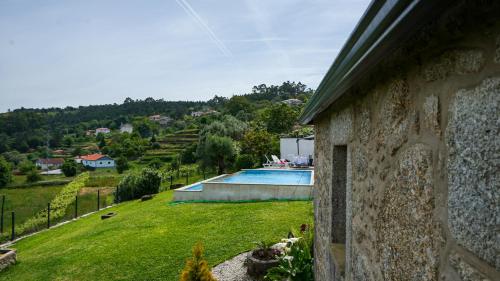a house with a yard with a swimming pool at A CASINHA DO CARREIRAS in Barroselas