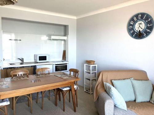 un salon avec une table et une cuisine dans l'établissement Lotus - Saint Hilaire de Riez, à Saint-Hilaire-de-Riez