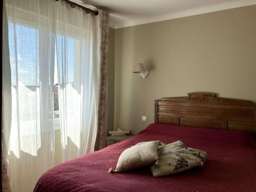 - une chambre avec un lit rouge et une grande fenêtre dans l'établissement Lotus - Saint Hilaire de Riez, à Saint-Hilaire-de-Riez