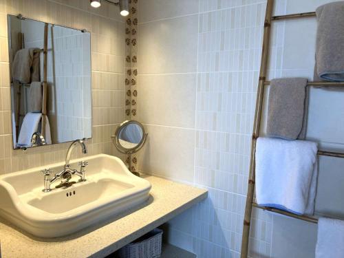 une salle de bain avec un lavabo et un miroir dans l'établissement Lotus - Saint Hilaire de Riez, à Saint-Hilaire-de-Riez