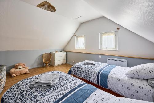 a attic bedroom with two beds and a teddy bear at Entre Histoire et Marais - Proche Plage in Carentan