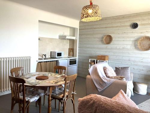 un salon avec une table et des chaises et une cuisine dans l'établissement Violette - Saint Hilaire de Riez, à Saint-Hilaire-de-Riez