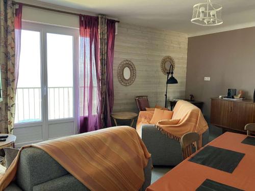 un salon avec un canapé et une fenêtre dans l'établissement Passiflore - Saint Hilaire de Riez, à Saint-Hilaire-de-Riez