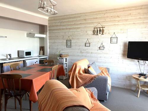 un salon avec une table et une cuisine dans l'établissement Passiflore - Saint Hilaire de Riez, à Saint-Hilaire-de-Riez