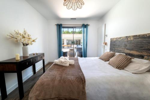 une chambre avec un grand lit avec une tête de lit en bois dans l'établissement Sunny Villa Nature, à Grayan-et-lʼHôpital