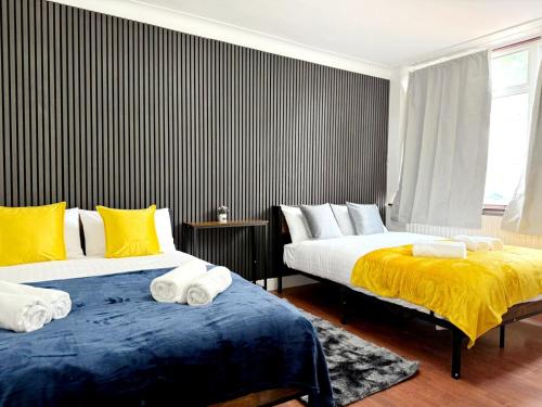 two beds sitting next to each other in a bedroom at BA-Excellent Room fits 4 in Wembley in London