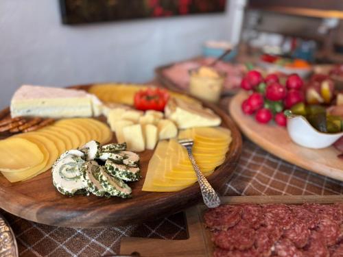 特伦德尔堡Gast- und Pensionshaus Pilgereck的切板上摆放着奶酪和其他食物的桌子