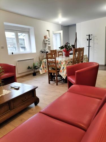 un salon avec un canapé rouge et une table dans l'établissement Grande maison en lieu calme proche nature Lacs, forêt, Parcs, à Raon-lʼÉtape