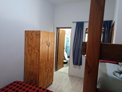 a bedroom with a bunk bed and a wooden cabinet at Hostel do Papai 3 in Lavras