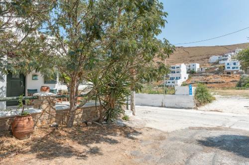 a fence in front of a house with a tree at Mouria Studio 4 in Kithnos