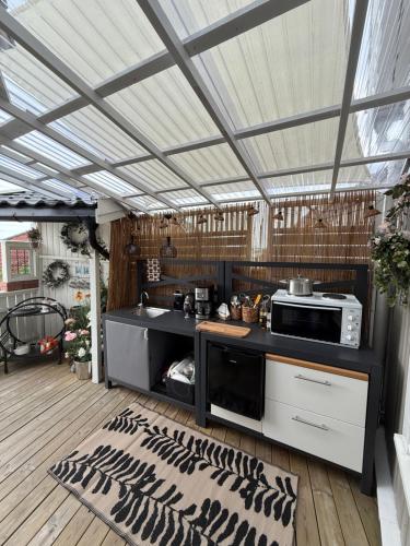 an outdoor kitchen with a counter and a microwave at Monas sommerresidens midt i hjertet av Kragerø in Kragerø