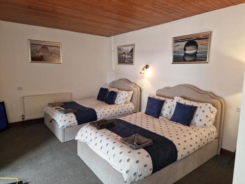 a bedroom with two beds and a couch at Fairladies Barn Guest House in St Bees