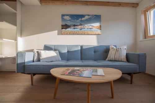a blue couch in a living room with a table at Villa Blau in Schruns-Tschagguns