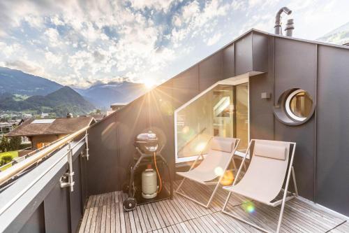 a balcony with two chairs and a vacuum at Villa Blau in Schruns-Tschagguns