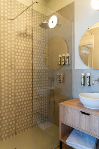 a bathroom with a glass shower with a sink at Hotel Querceto Wellness & Spa - Garda Lake Collection in Malcesine