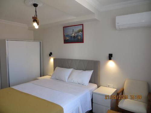 a small bedroom with a bed and a chair at Stella Blu Apartments in Fethiye