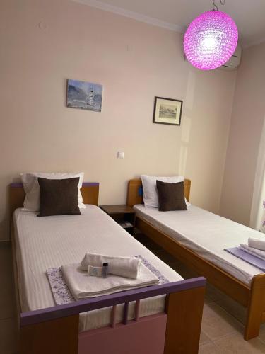 two twin beds in a room with a pink light at Thermos House Nydri in Nydri