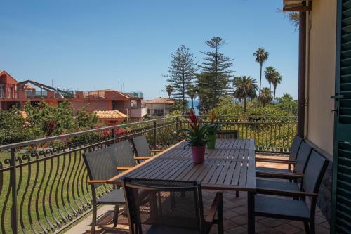 a wooden table and chairs on a balcony at Silvanae Pool Villa in Aci Castello