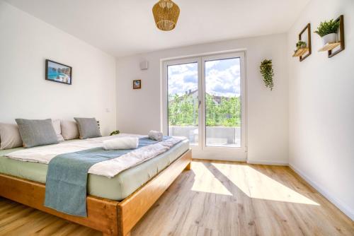 a bedroom with a bed and a large window at Garten, Küche, Parkplatz & Mehr - Komfort Apartment Bavaria in Scheyern