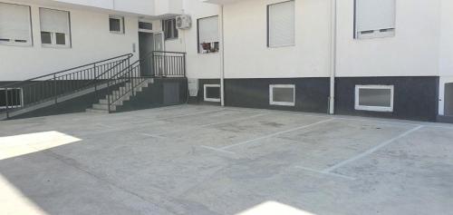 an empty parking lot in front of a building at Apartman Aura in Petrovaradin