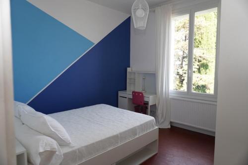- une chambre bleue et blanche avec un lit et une fenêtre dans l'établissement Villa de charme, vue mer, baignée de soleil, à Grasse