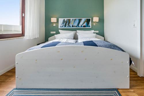 a bed in a bedroom with a white bed frame at Landhaus Ostseeblick Fewo 4 - in Kronsgaard