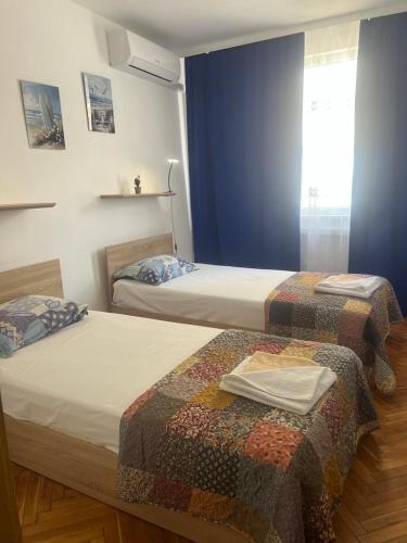 two beds in a hotel room withthritisthritislictslictslicts at Апартамент Иванови in Pomorie