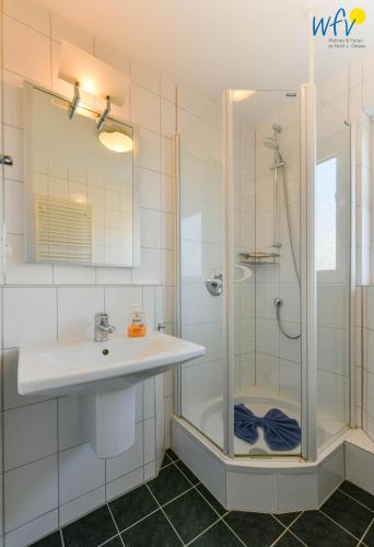 a bathroom with a sink and a shower at Ferienhaus Caterlieschen Ferienwohnung 1 in Juist
