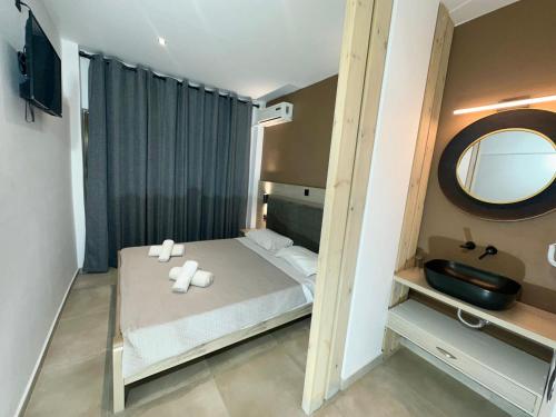 a small bedroom with a bed and a mirror at Aegean Pearl in Tigaki