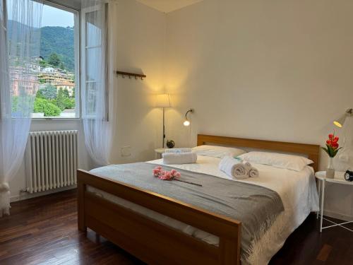 a bedroom with a large bed with a large window at Casa Valeria - a due passi dal Traghetto in Cernobbio