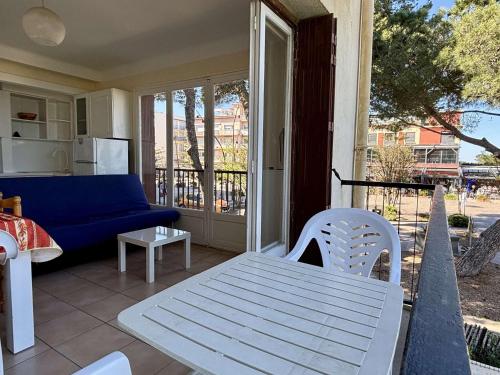 une terrasse couverte avec un canapé bleu, une table et des chaises dans l'établissement Appartement 2 pièces 4 couchages ARGELES SUR MER AR110-005, à Argelès-sur-Mer