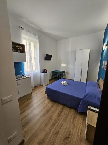 a bedroom with a blue bed and a kitchen at Luna Rossa in Ladispoli