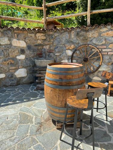 a large barrel and a chair and a stone wall at Agri Alloggio La Quercia e il Frassino in Fino del Monte