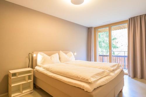 a bedroom with a large bed and a window at Edelweiss Ferienwohnung, Vista Flem in Flims