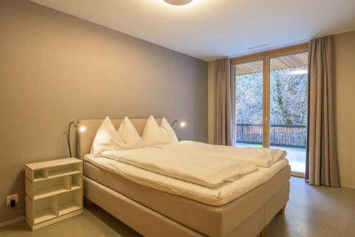 a bedroom with a bed and a large window at Edelweiss Ferienwohnung, Stenna Flims in Flims