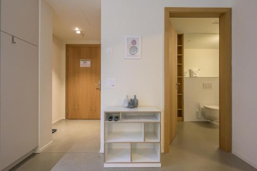 a bathroom with a toilet and a white table at Edelweiss Ferienwohnung, Stenna Flims in Flims