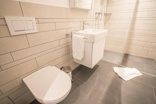 a white bathroom with a toilet and a sink at Edelweiss Ferienwohnung, Stenna Bergblick in Flims