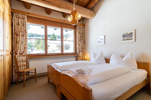 a bedroom with two beds and a window at Edelweiss Darblauna Sut in Flims