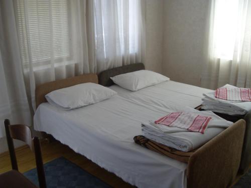 a bed with white sheets and pillows on it at Residence Krstanoski in Ohrid