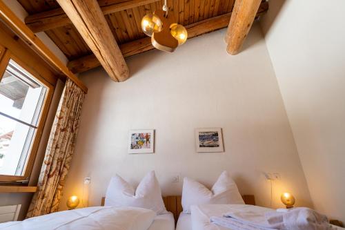 a bedroom with two white beds and a window at Edelweiss Darblauna Sut in Flims