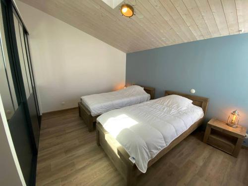 a bedroom with two beds in a room at La Villa Marite in La Flotte