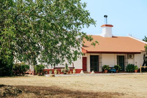 a white house with an orange roof at Dehesa de la yeguas-Finca privada con piscina a 15 min playas in Cádiz