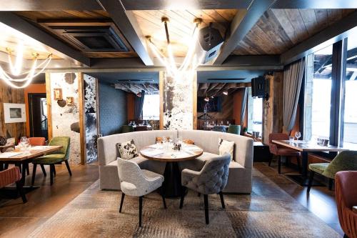 a restaurant with tables and chairs in a room at SNOW PEAK TODORKA AND VIHREN APARTAMENT /NEXT TO THE LIFT/ 7 PERSONS/ in Bansko