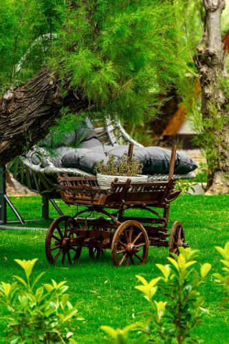 a wooden cart with a bed on the grass at Nest Beach Bungalows Datça in Datca
