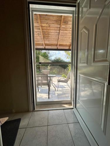 a door leading to a patio with a table outside at Cozy house near Preveza in Flámpoura