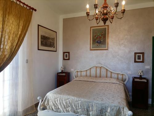 a bedroom with a bed and a chandelier at Affittacamere Genia in Pisa