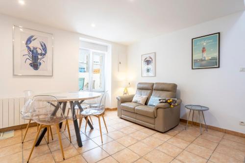 un salon avec une table et un canapé dans l'établissement La pince de crabe à 300m de la mer, au Guilvinec