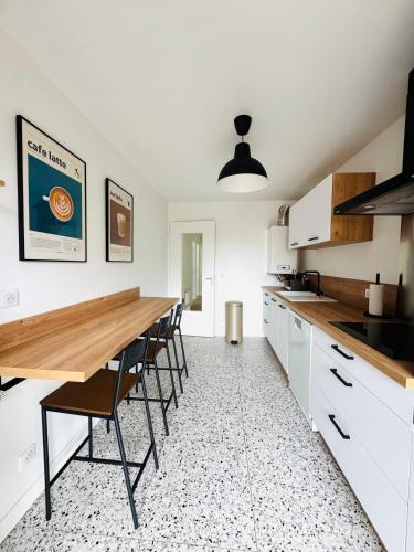 une cuisine avec une grande table et des chaises en bois dans l'établissement Magnifique T3 avec terrasse, à Clermont-Ferrand